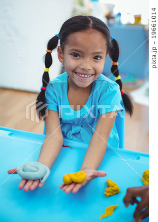 Smiling girl using modelling clay Smiling girl using modelling clay 19661014