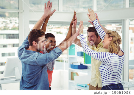 Happy creative team giving high fives to each other 19661038