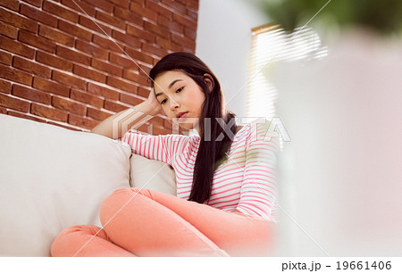 Upset asian woman on couch  19661406