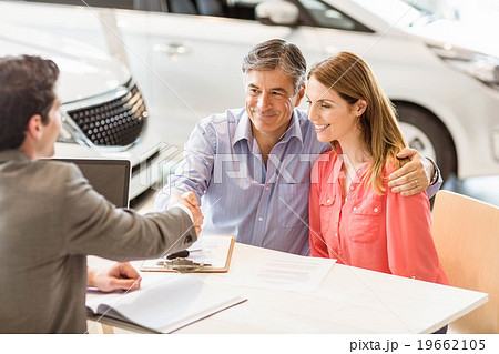 Smiling couple buying a new car Smiling couple buying a new car 19662105