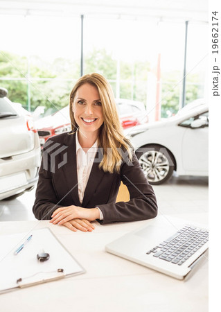 Smiling saleswoman behind her desk 19662174