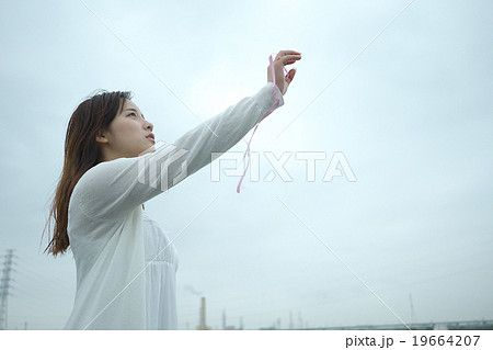 空に手を伸ばす女性の写真素材