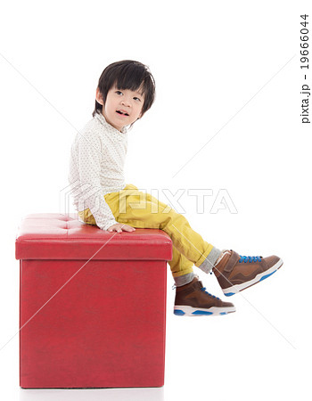 Cute asian boy sitting on red stool isolated 19666044