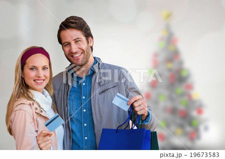 Composite image of smiling couple with shopping bags showing cre Composite image of smiling couple with shopping bags showing cre 19673583