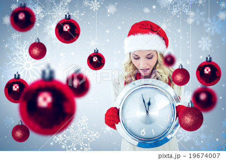 Composite image of happy festive blonde with clock 19674007