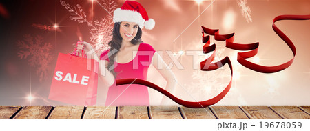 Composite image of festive brunette holding sale bag Composite image of festive brunette holding sale bag 19678059