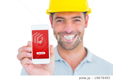 Composite image of portrait of smiling handyman showing smart phone 19678465