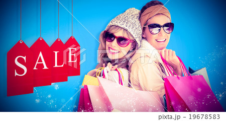 Composite image of beautiful women holding shopping bags looking at camera Composite image of beautiful women holding shopping bags looking at camera 19678583