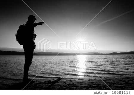 Man with hand in the air, sunset at horizon Man with hand in the air, sunset at horizon 19681112