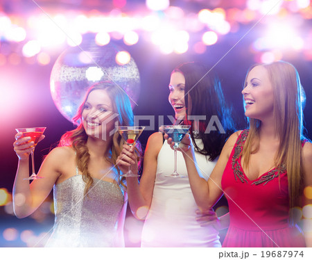 smiling women with cocktails at night club smiling women with cocktails at night club 19687974