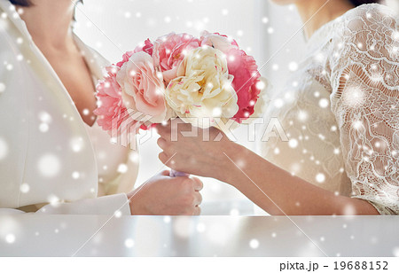 close up of happy lesbian couple with flowers 19688152