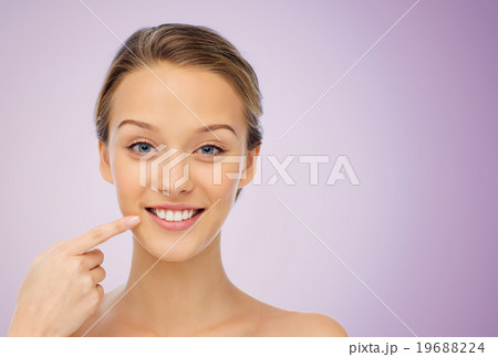 happy young woman pointing finger to her smile happy young woman pointing finger to her smile 19688224