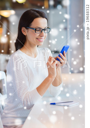 smiling woman with smartphone at cafe 19688312