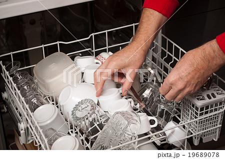 closeup of man take clean dishes in dishwasher 19689078