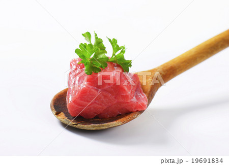 Raw beef meat on wooden spoon 19691834
