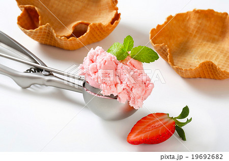 Scoop of strawberry ice cream and waffle baskets 19692682