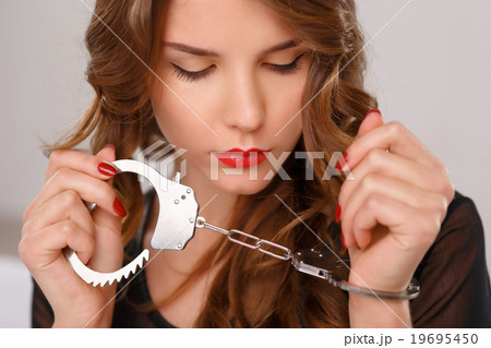 Appealing young girl posing with handcuffs. Appealing young girl posing with handcuffs. 19695450