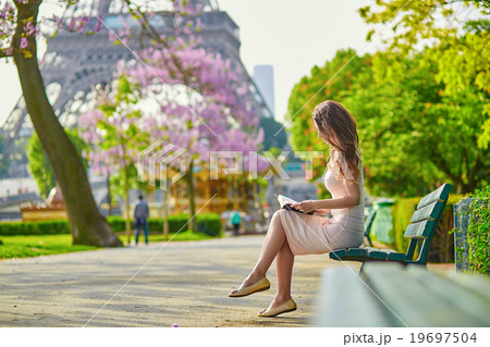 Beautiful young woman in Paris, reading a book Beautiful young woman in Paris, reading a book 19697504