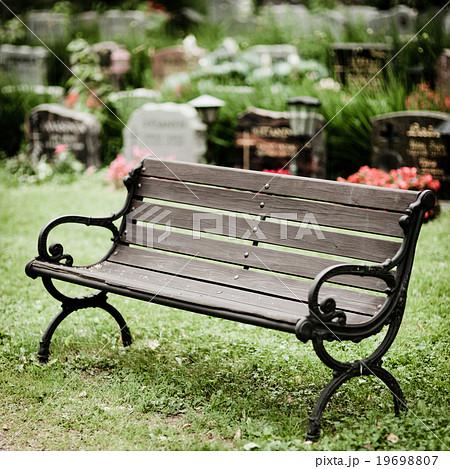 Empty old wooden bench in cemetery 19698807
