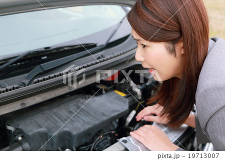 仕事 スーツ 車 エンジントラブル 女性 軽自動車 運転手 ビジネスウーマン 営業 運転免許 の写真素材