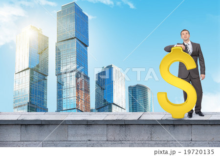 Businessman standing with big dollar sign Businessman standing with big dollar sign 19720135