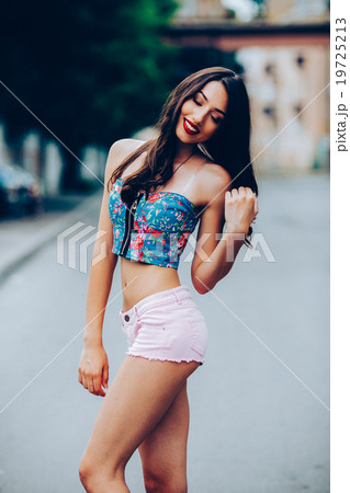 beautiful girl poses for camera in the city 19725213