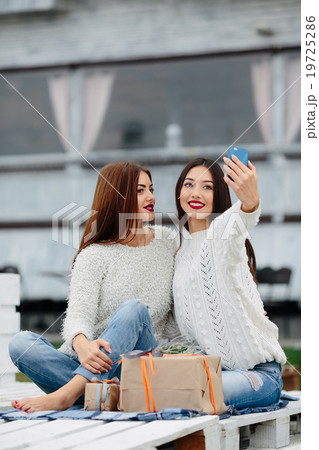 Two girls make selfie with gifts Two girls make selfie with gifts 19725286