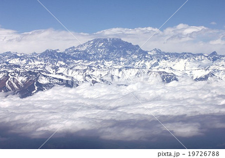 雲海に浮かぶ南米最高峰アコンカグアをアンデス山脈上空から見るの写真素材