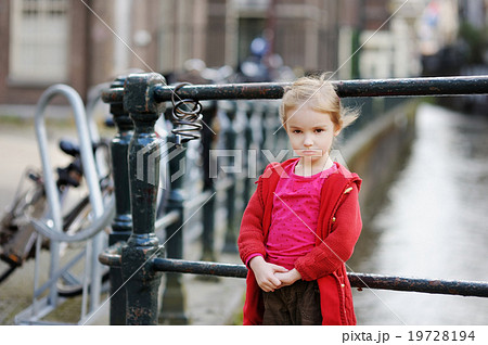 Little girl standing by a row of bicycles Little girl standing by a row of bicycles 19728194