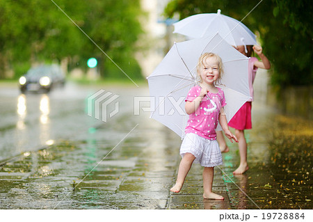 Two cute little sisters on a rainy summer day 19728884