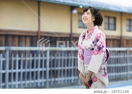浴衣を着て古い家並みの前に立っている若い女性 19731130