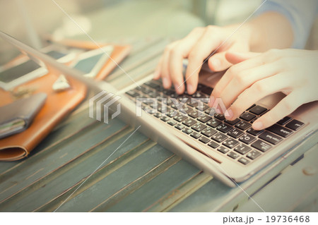Hands typing on laptop and smart phone on his side Hands typing on laptop and smart phone on his side 19736468