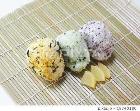 巻すにのせた3個のおにぎりとタクアンの写真素材 巻すにのせた3個のおにぎりとタクアンの写真素材