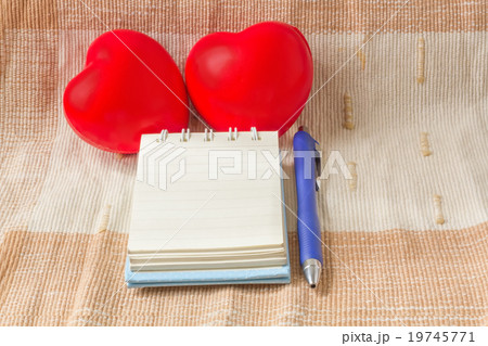 Double red heart with blank notebook on fabric Double red heart with blank notebook on fabric 19745771