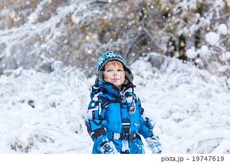Happy child having fun with snow in winter Happy child having fun with snow in winter 19747619