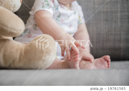 Baby girl (12-17 months) holding foot Baby girl (12-17 months) holding foot 19761565