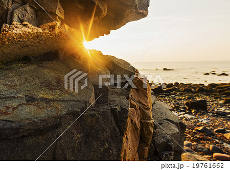 Rock formations on beach and sea at sunrise 19761662