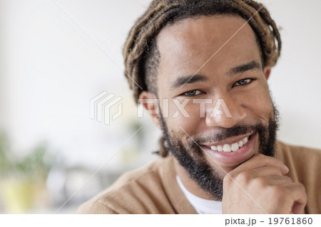Portrait of smiley young man with hand on chin Portrait of smiley young man with hand on chin 19761860