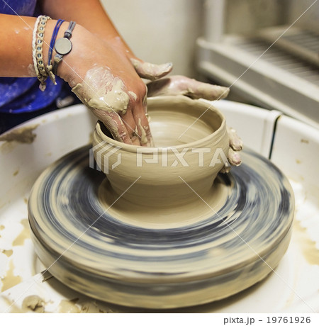 Woman shaping clay bowl on pottery wheel Woman shaping clay bowl on pottery wheel 19761926