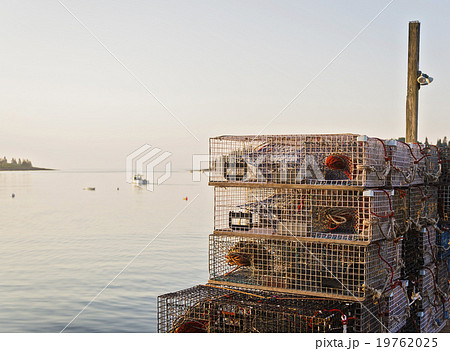 Stacks of lobster traps by sea at sunrise Stacks of lobster traps by sea at sunrise 19762025