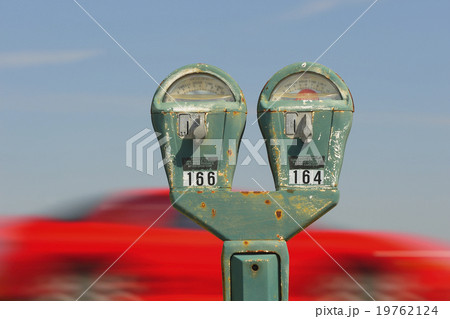 Old parking meter against panning red car 19762124