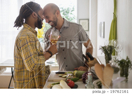 Smiley homosexual couple drinking wine in kitchen 19762161