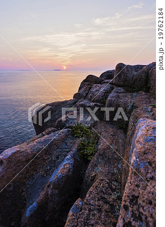 Rocky cliff by sea at sunrise 19762184