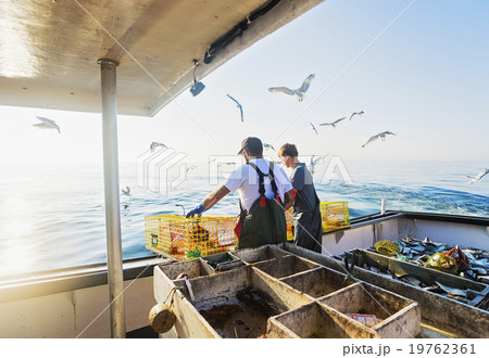 Two fishermen throwing lobster traps Two fishermen throwing lobster traps 19762361