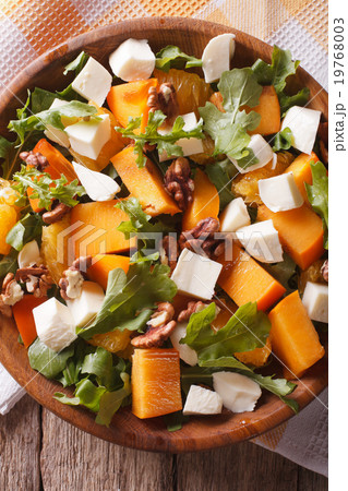 salad with persimmon, arugula and cheese closeup salad with persimmon, arugula and cheese closeup 19768003