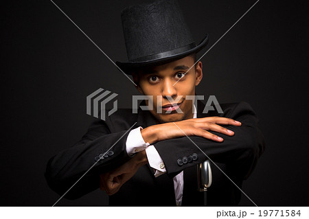 Handsome man in top hat posing with cane Handsome man in top hat posing with cane 19771584