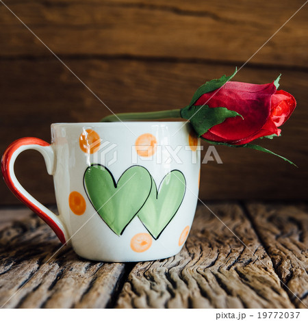 Vintage love cup with rose on old wood background. Vintage love cup with rose on old wood background. 19772037