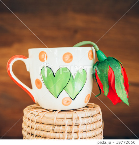 Vintage love cup with rose on old wood background. Vintage love cup with rose on old wood background. 19772050