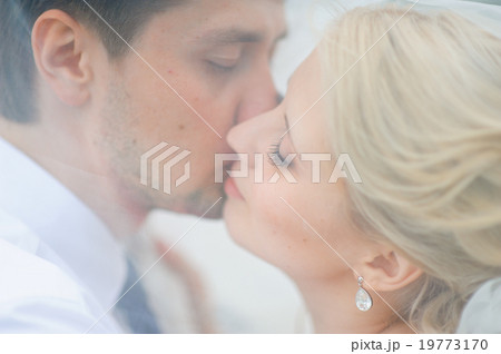 love the bride and groom are covered with a veil and kiss love the bride and groom are covered with a veil and kiss 19773170