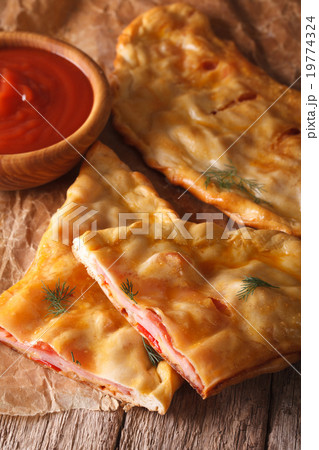 Cut Italian pizza calzone with ham and cheese 19774324
